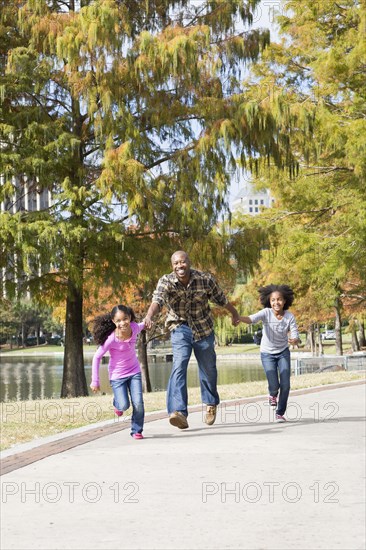 Father and daughters playing in park