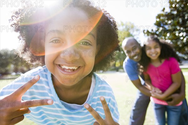 Father and daughters smiling in park