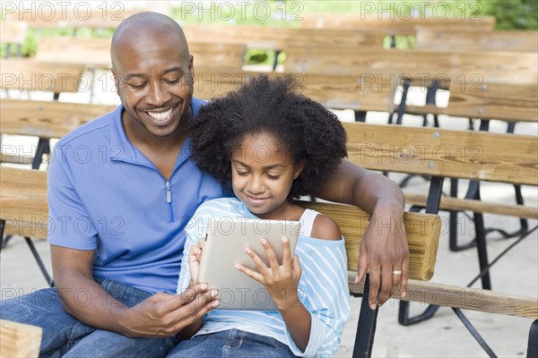 Father and daughter using tablet computer
