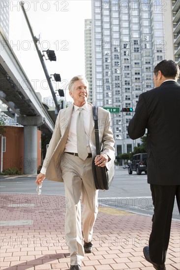 Caucasian businessman walking on city street