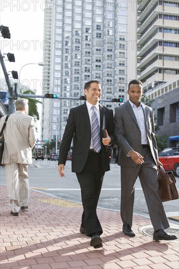 Businessmen walking together on city street
