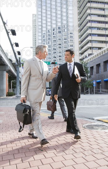 Businessmen walking together on city street