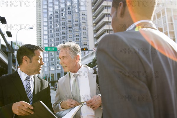 Businessmen talking on city street