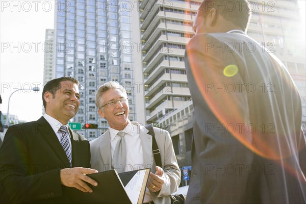 Businessmen talking on city street