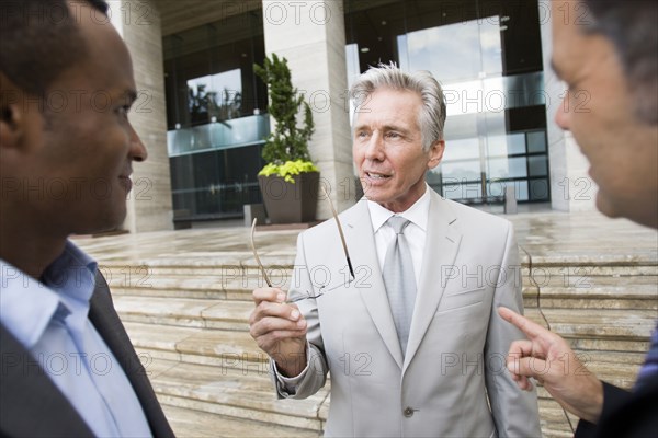 Businessmen talking on city street