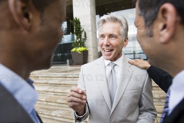 Businessmen talking on city street