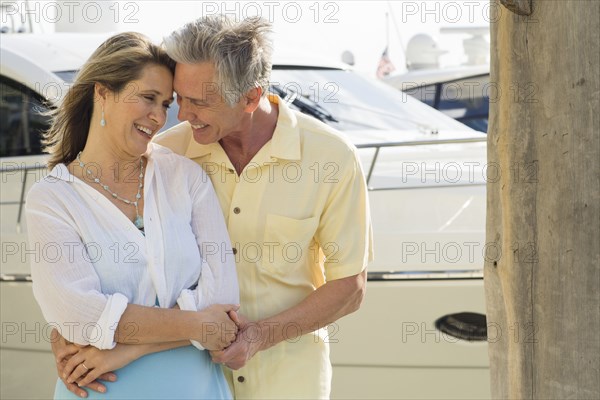 Caucasian couple hugging on dock