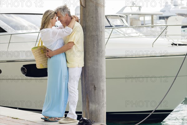 Caucasian couple hugging on dock