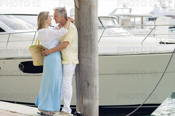 Caucasian couple hugging on dock