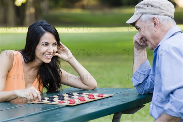 Hispanic father and daughter playing checkers
