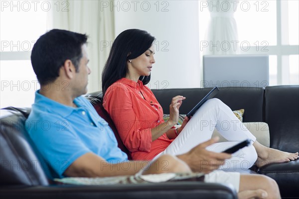 Hispanic couple relaxing on sofa