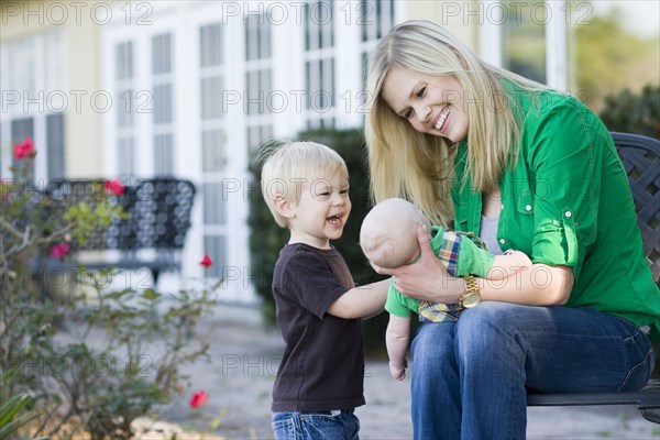 Caucasian mother relaxing with children in garden