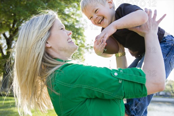 Caucasian woman playing with son