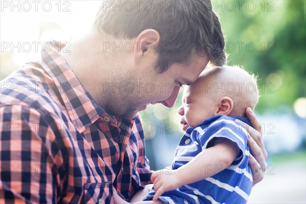 Caucasian father holding baby outdoors