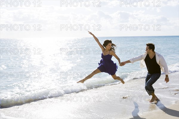 Couple playing in surf on beach