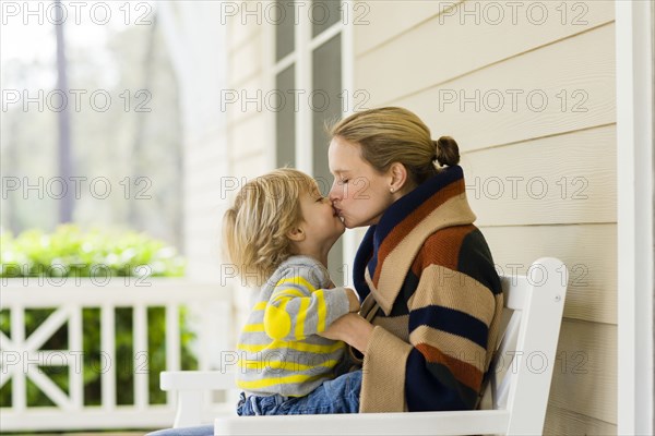 Caucasian mother and son kissing