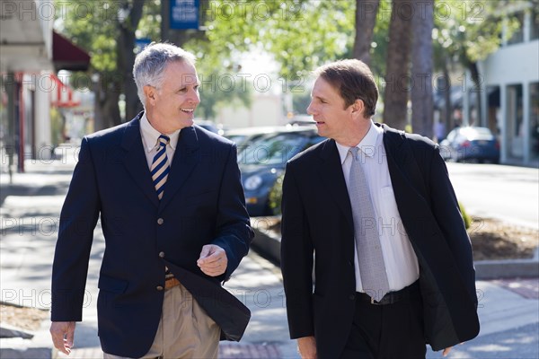 Caucasian businessmen walking on city street