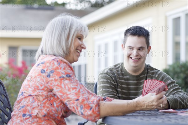 Caucasian mother and disabled son playing cards