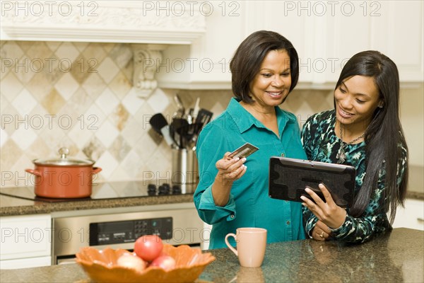 African American mother and daughter using digital tablet