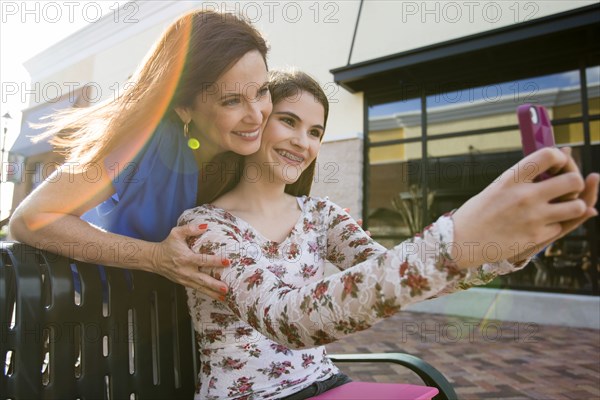 Caucasian mother and daughter taking self-portrait