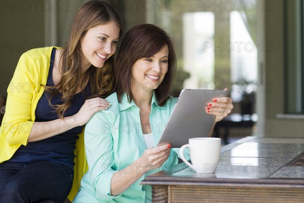 Caucasian mother and daughter using digital tablet