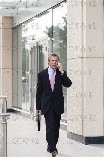 Caucasian businessman on cell phone outdoors