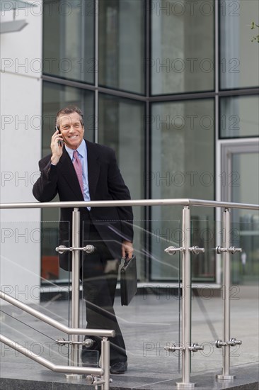 Caucasian businessman on cell phone outside building