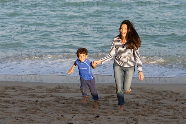 Caucasian mother and son playing on beach