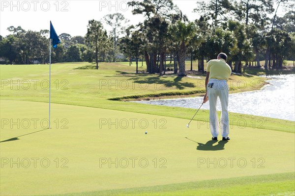 Caucasian man putting on golf course