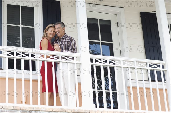 Caucasian couple dancing on balcony