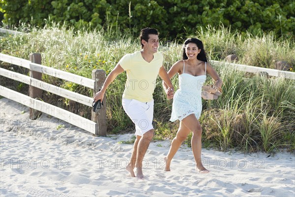 Hispanic couple walking on beach