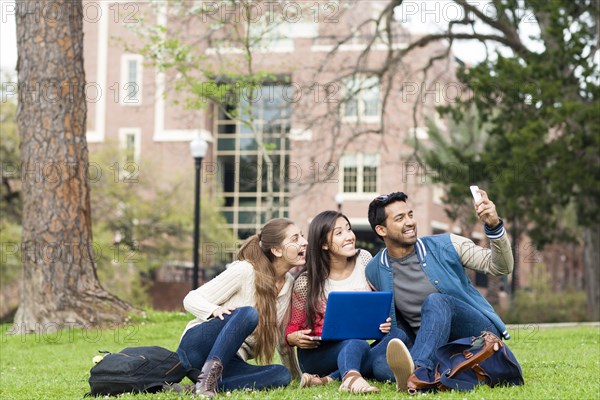 Students taking cell phone photograph on campus