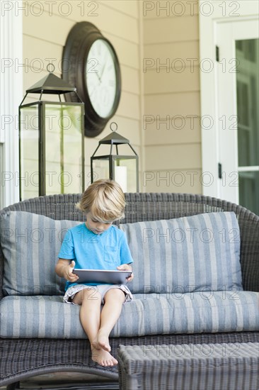 Caucasian boy using digital tablet on sofa