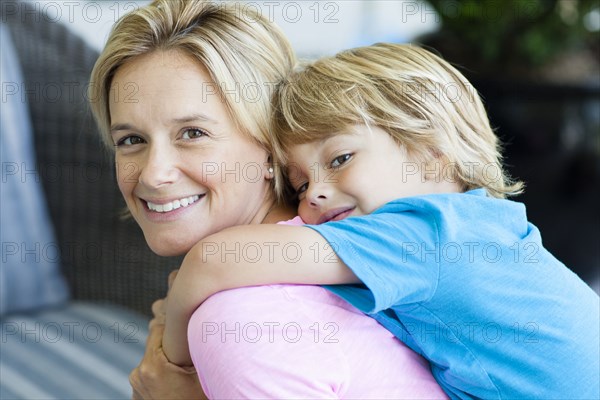 Caucasian mother carrying son piggyback