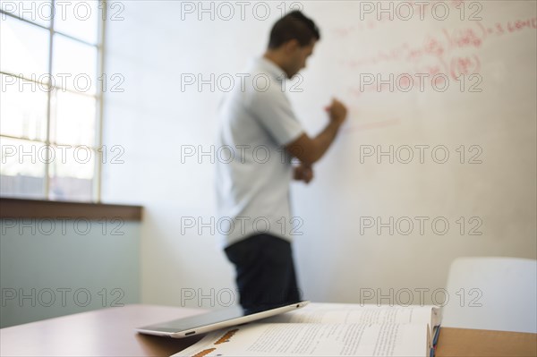 Asian businessman writing on whiteboard