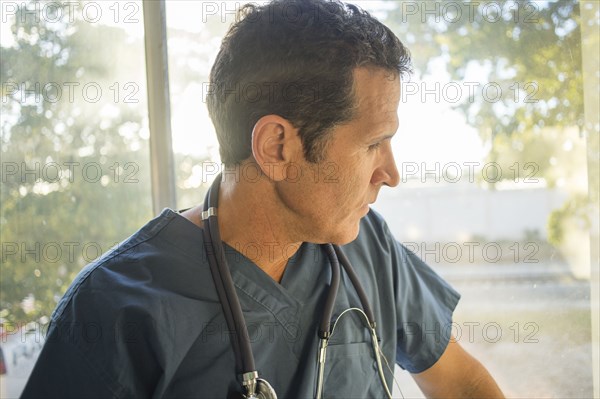 Hispanic doctor looking out window