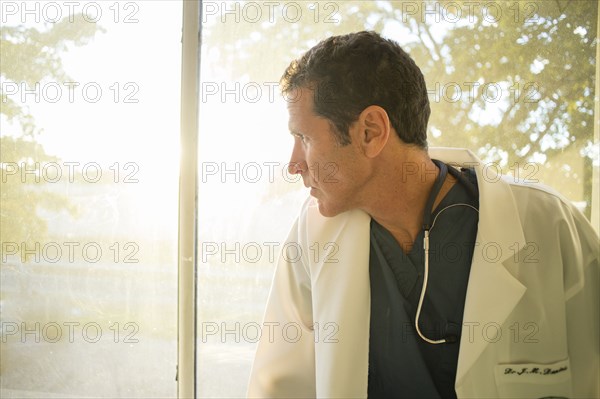 Hispanic doctor looking out window