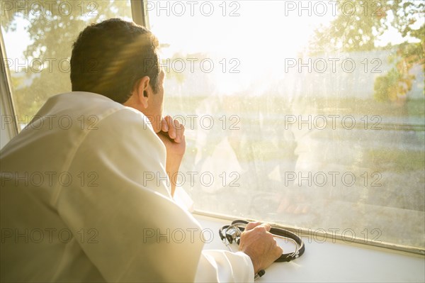 Hispanic doctor looking out window