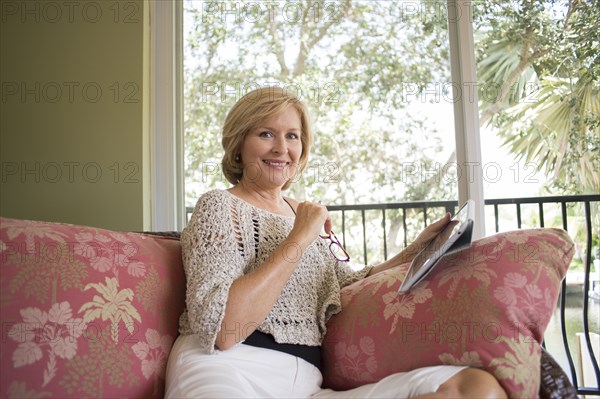 Caucasian woman using digital tablet on sofa