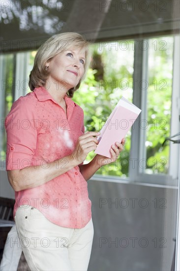 Smiling Caucasian woman reading card
