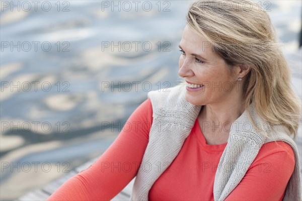 Smiling Caucasian woman rowing canoe on lake