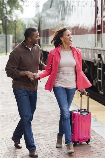 Man walking girlfriend to train at station