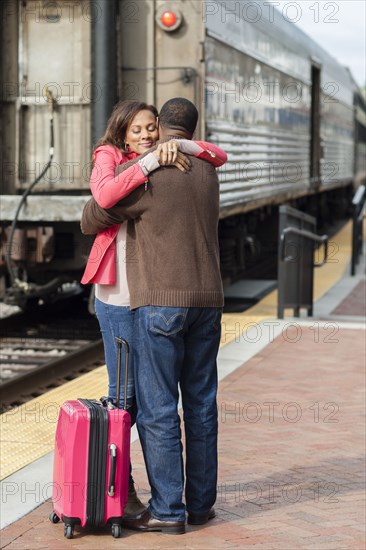 Couple hugging at train station