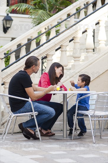 Caucasian family eating at sidewalk cafe