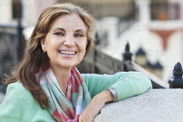 Middle Eastern woman leaning on gate