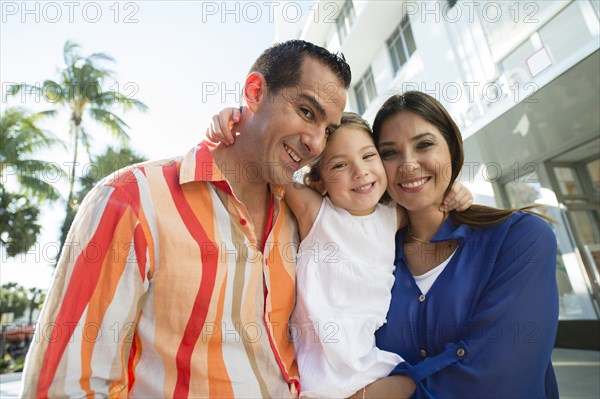 Close up of Hispanic family hugging outdoors