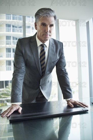 Caucasian businessman standing at desk in office