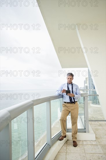 Caucasian businessman using digital tablet on balcony