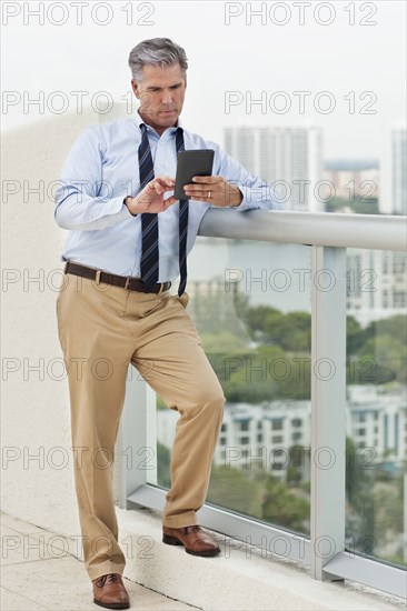 Caucasian businessman using digital tablet on balcony