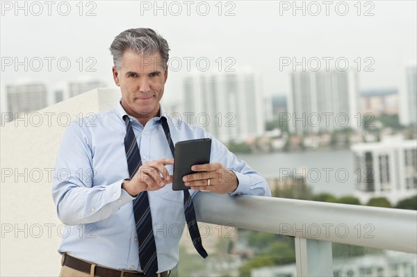 Caucasian businessman using digital tablet on balcony